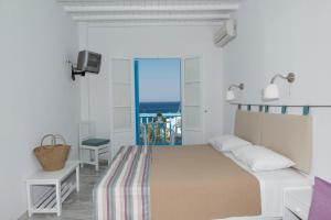 a bedroom with a bed and a view of the ocean at Asimina in Tourlos