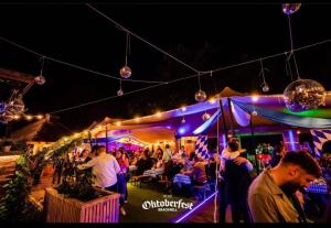 a crowd of people standing under a tent at a party at The Admiral Cunningham Hotel in Bracknell