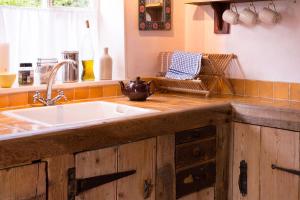 a kitchen with a sink and a counter top at Farm Cottage a cute C17th cottage a walk across the fields to a great pub 