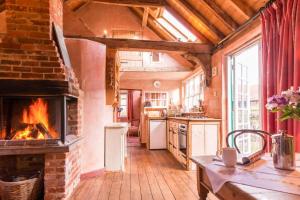 a kitchen with a brick fireplace in a house at Rose Cottage rural cosiness with footpaths to the local Macro Brewery Pub 