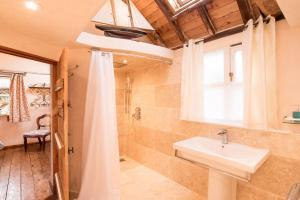 a bathroom with a sink and a shower at Snow Cottage laid back style with footpaths to a great Macro Brewery Pub 