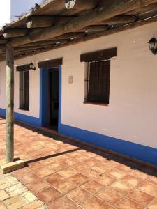 edificio blu e bianco con finestre e pavimento piastrellato di CASA KIKA ROCIO a El Rocío