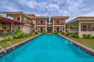 a swimming pool in front of a villa at Guru Beach Resort in Tangalle