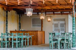 a group of green tables and chairs in a room at Guru Beach Resort in Tangalle