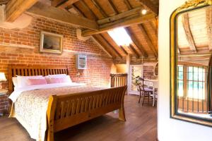 a bedroom with a bed and a brick wall at Dons Barn a Stunning cottage just a walk across the fields to a great pub 