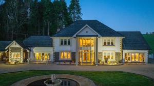 a large white house with its lights on at Plas Y Dderwen Apartments in Aberystwyth