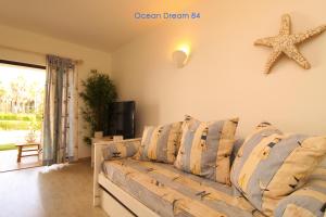 - un salon avec un canapé et une étoile de mer sur le mur dans l'établissement Ocean Dream 84 - Apt. T1 na Praia de São Rafael, Albufeira, à Albufeira