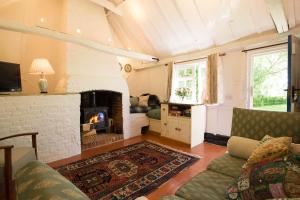 a living room with a couch and a fireplace at The Wobbin, Remote, Comfort, Sea Views and the beautiful Essex Marshes in West Mersea