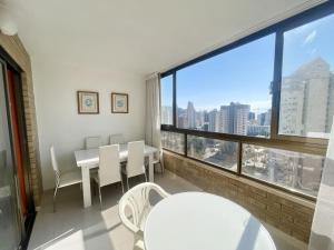 a room with a table and chairs and a large window at Paraiso 10 Blueline in Benidorm