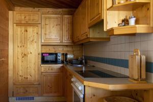 kuchnia z drewnianymi szafkami i blatem w obiekcie Wallackhaus hütte w mieście Untertauern
