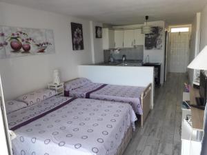 a room with three beds and a kitchen in it at Borinquen con vista mar in Playa Fañabe