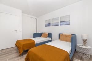 2 camas en una habitación con paredes blancas en Akisol Olhão Sand, en Olhão