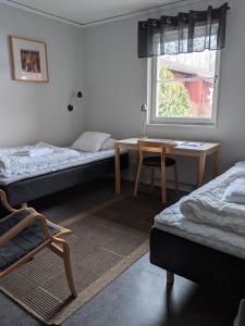 Zimmer mit 2 Betten, einem Tisch und einem Fenster in der Unterkunft Valla Folkhögskola in Linköping
