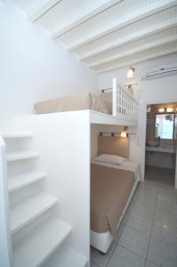 1 dormitorio con litera en una habitación blanca en Asimina, en Tourlos