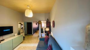 ein Wohnzimmer mit einem blauen Sofa und einem TV in der Unterkunft Stunning 1-Bed House in Tema- Oheneba villa in Tema