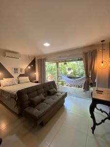 um quarto com uma cama, um sofá e uma janela em Villas do Pratagy Temporada em Maceió
