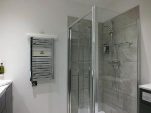 um chuveiro com uma porta de vidro na casa de banho em The Piebald Inn em Hunmanby