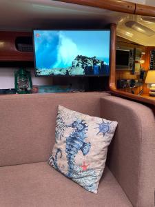 a pillow sitting on the back of a couch with a tv at Segelyacht Bremen City in Bremen