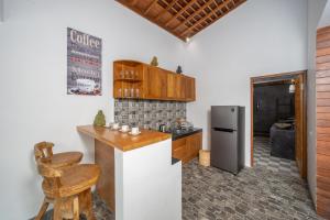 una cucina con bancone e frigorifero di The Secret Jungle Villas Berawa a Canggu
