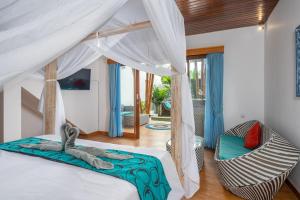 una camera da letto con un letto e una sedia in una stanza di The Secret Jungle Villas Berawa a Canggu