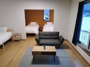a living room with a couch and two beds at All Seasons Furano Chalet in Furano