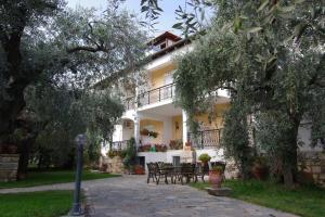 un bâtiment avec des tables et des chaises devant lui dans l'établissement Effi's Garden Villa, à Thasos