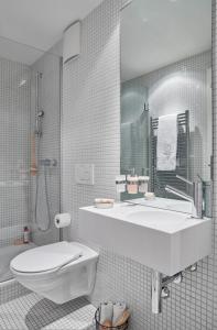 VISIONAPARTMENTS Binzmühlestrasse 46 - contactless check-in في زيورخ: حمام أبيض مع حوض ومرحاض