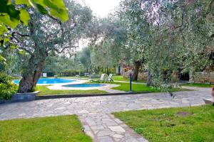 a garden with a swimming pool and trees and grass at Effi's Garden Villa in Limenas
