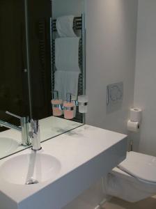 a white bathroom with a sink and a mirror at VISIONAPARTMENTS Binzmühlestrasse 46 - contactless check-in in Zürich
