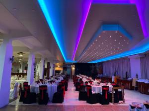 un salón de banquetes con mesas, sillas y luces púrpuras en Hotel Spring View, en Matale