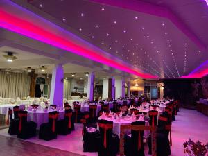 un salón de banquetes con mesas, sillas e iluminación púrpura en Hotel Spring View, en Matale