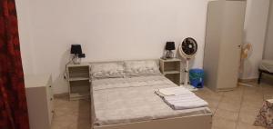 ノヴァーラにあるCasa Manzoniのベッドルーム1室(ベッド2台、壁掛け時計付)