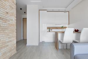 a kitchen with a table and chairs and a brick wall at Elite Apartments Sunny in Gdańsk