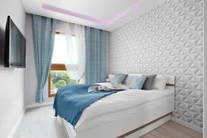 sypialnia z łóżkiem z niebieskim kocem w obiekcie Elite Apartments Sunny w Gdańsku