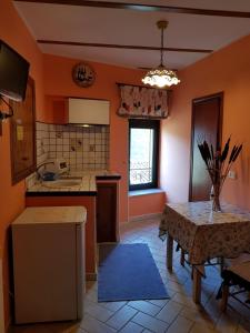 cocina con paredes de color naranja, mesa y ventana en Maison Dina en Collepardo