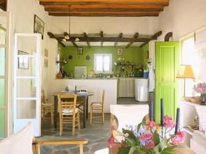 a living room with a table and a kitchen with green walls at Katzilieris Country House in Naxos Chora