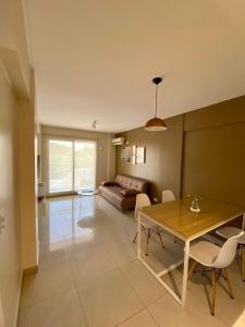 ein Wohnzimmer mit einem Tisch und einem Sofa in der Unterkunft 9 de Julio Park Suites in San Miguel de Tucumán