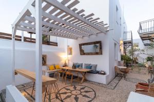 a patio with a wooden table and chairs at F Charm all Suites - Adults Only in Lindos