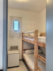 Cette chambre dispose de lits superposés, de 2 lits superposés et d'une fenêtre. dans l'établissement Confortable appartement à 700m de la plage de Valras !, à Valras-Plage