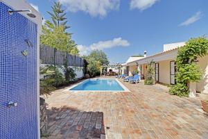 un patio trasero con piscina y una casa en Algarve Country Villa With Pool by Homing, en Santa Bárbara de Nexe