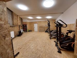 einen Fitnessraum mit Laufbändern und Heimtrainern in einem Zimmer in der Unterkunft Pension Dreger in Freimersheim