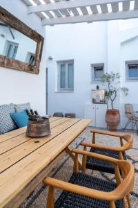 a wooden table and bench in a room with a mirror at F Charm all Suites - Adults Only in Líndos