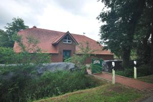 ein Haus mit einem Schild davor in der Unterkunft Ferienhaus Eichenhof 35648 in Uplengen