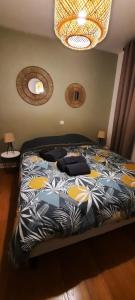 a bedroom with a bed with a black and yellow comforter at Appartement Centre ville proche gare in Dunkerque