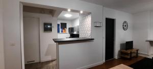 a kitchen with white walls and a black counter top at Appartement Centre ville proche gare in Dunkerque