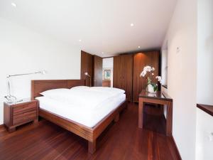Schlafzimmer mit einem großen weißen Bett und Holzböden in der Unterkunft Apartment Ronch in Selva
