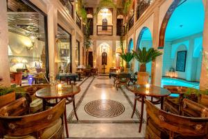 un hall avec des tables et des chaises ainsi qu'une piscine dans l'établissement Dar Anika, à Marrakech