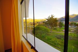 a window with a view of a green field at Hotel Sierra Dorada in Ayacucho