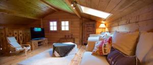 a room with a couch and a tv in a cabin at Cosy Chalet 50m du lac, une exclusivité LLA Selections by Location Lac Annecy in Doussard