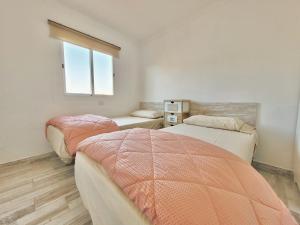 sypialnia z dwoma łóżkami i oknem w obiekcie CristianPlaya Attic w mieście Los Cristianos